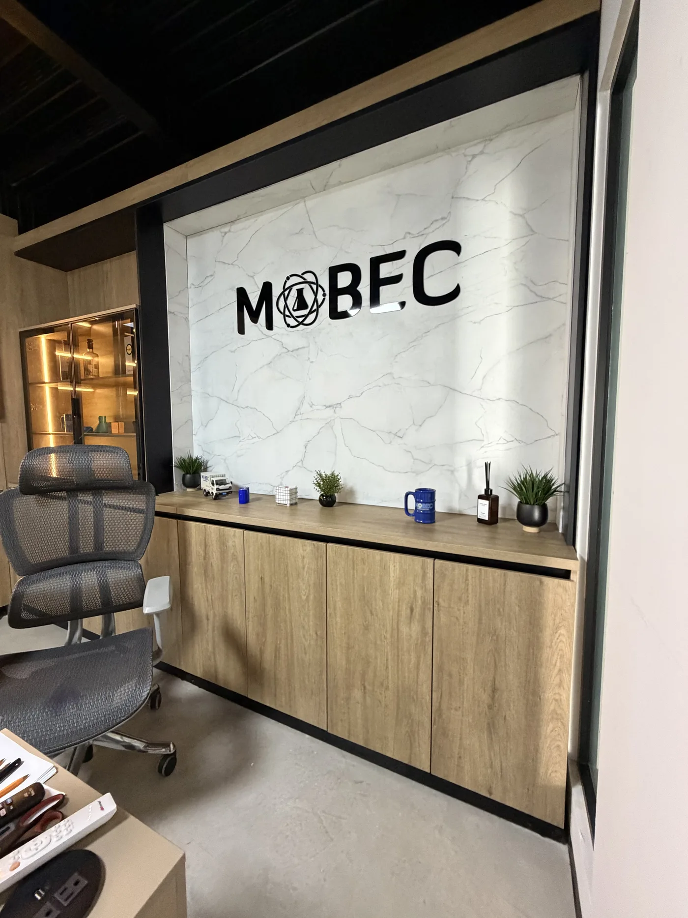 Credenza corrida de madera bajo el muro de mármol