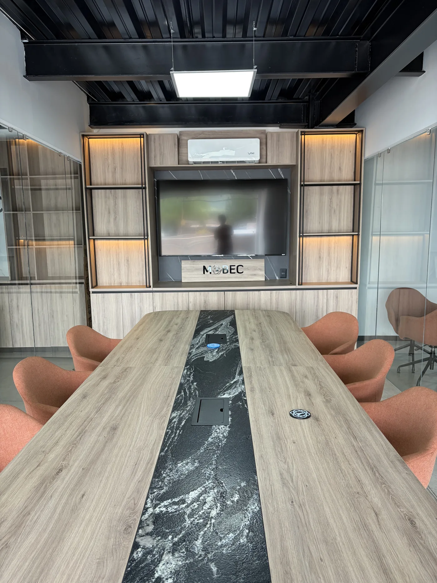 Sala de juntas con mesa larga y franja de mármol negro